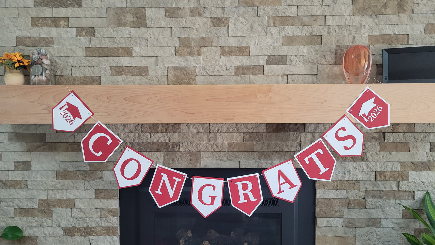 Graduation 'CONGRATS' banner on a fireplace with graduation cap and year design